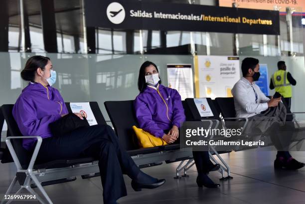 Employees of different airlines sit near the departure gate of international flights at El Dorado International Airport on August 31, 2020 in Bogota,...