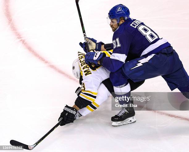 Brad Marchand of the Boston Bruins is checked by Erik Cernak of the Tampa Bay Lightning during the first overtime period in Game Five of the Eastern...