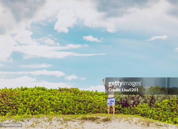 carefree happy man raises his arms up on a beach - stuart florida imagens e fotografias de stock