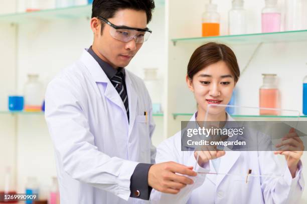 scientist discussing in the laboratory - lunette de protection photos et images de collection