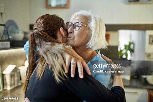 caucasian mother and adult daughter embracing - emotional support stock pictures, royalty-free photos & images