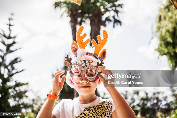 portrait of boy (7) wearing reindeer antlers and xmas googles in summer time - child christmas costume stock pictures, royalty-free photos & images