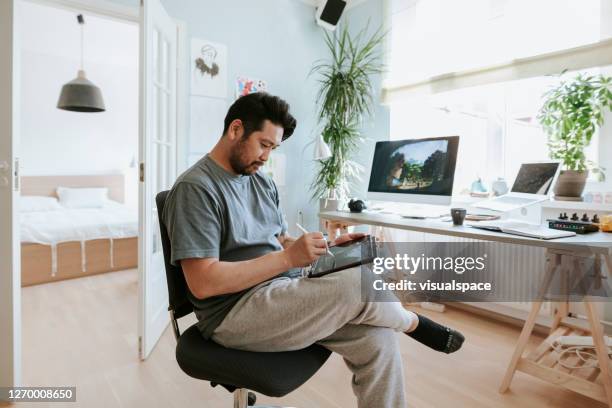 digital artist drawing on digital table in his home studio - jogging pants stock pictures, royalty-free photos & images