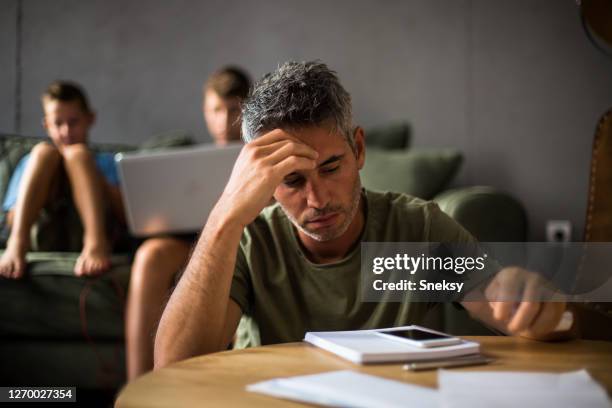 worried father looking at financial bill - emotional stress family stock pictures, royalty-free photos & images