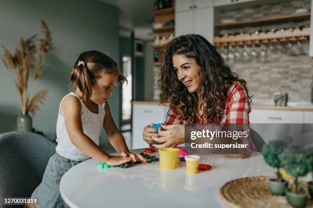 mother is playing with modelling clay with her daughter - clay stock pictures, royalty-free photos & images