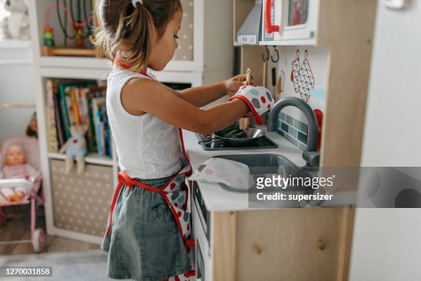 girl playing in the mini kitchen - children playing with toys imagens e fotografias de stock