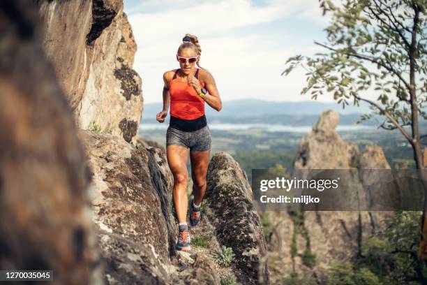 junge frau läuft auf berg - trailrunning stock-fotos und bilder