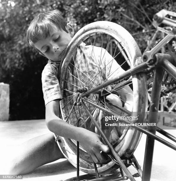 Enfant réparant son vélo.