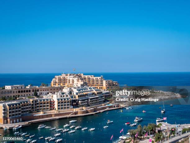 st george's bay in paceville st julian's malta. showing apartments, hotels and boats in the harbour waterfront - st julians bay stock pictures, royalty-free photos & images
