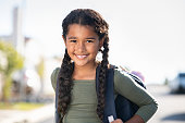 Smiling elementary school girl with bagpack