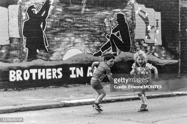 Enafnts jouant devant une peinture murale en faveur de l'IRA le 4 septembre 1979 à Belfast en Irlande du Nord