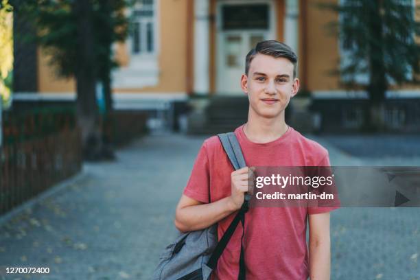 lächelnder schuljunge auf dem schulhof - teenager männlich stock-fotos und bilder