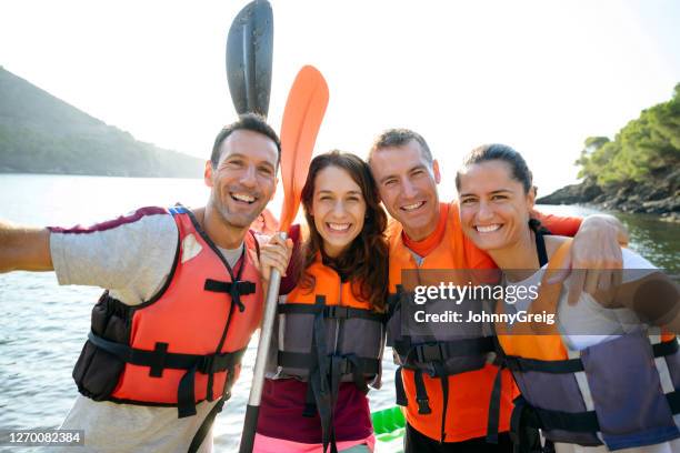 group portrait of cheerful spanish kayakers ready to paddle - summer kayaking stock pictures, royalty-free photos & images