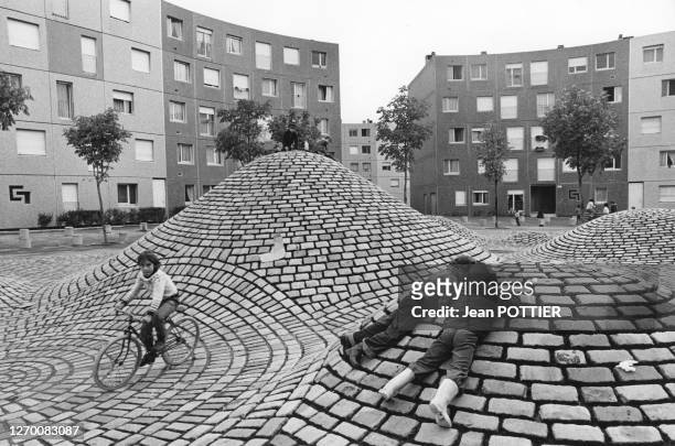 Enfant faisant du vélo sur les buttes en pavés d'un parc de la cité de La Grande Borne à Grigny, dans l'Essonne, le 27 octobre 1976, France.