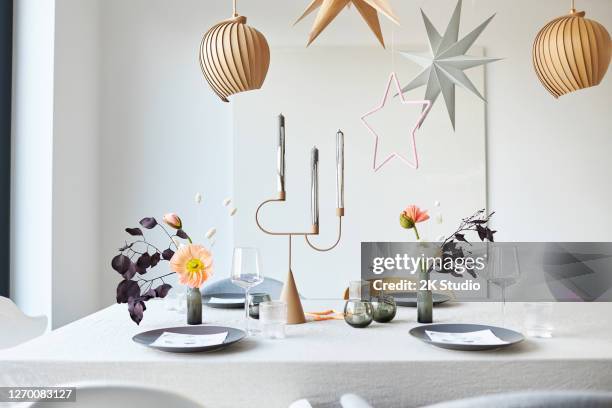 een moderne en eenvoudig ontworpen de decoratie van de lijst van kerstmis met komstskrans, sterren en bloemen die in hoge resolutie worden gefotografeerd - christmas lifestyle stockfoto's en -beelden