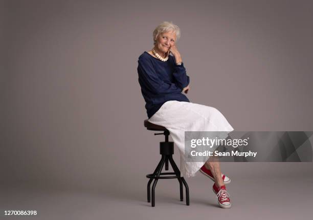 portrait of a stylish mature woman in her early 70's against a seamless backdrop - woman on plain background stock pictures, royalty-free photos & images