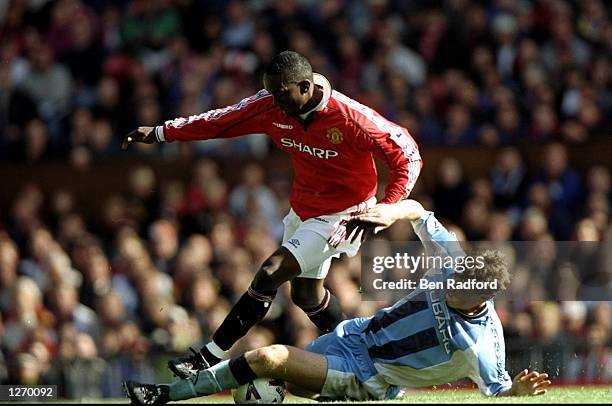 Dwight Yorke of Manchester United is tackled by Trond Egil Soltvedt of Coventry City during the FA Carling Premiership match at Old Trafford in...