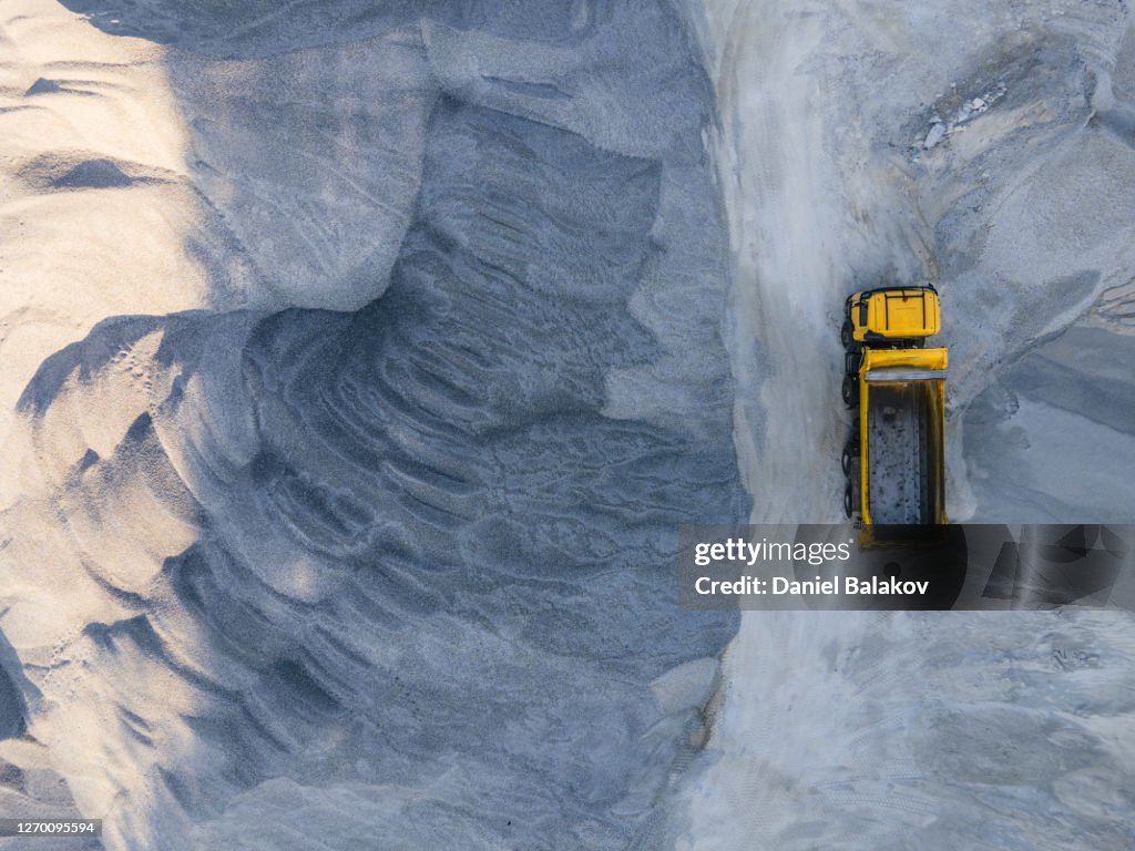 Building new highways in the mountain. Aerial view directly above over a highway construction site in the mountains, top view, cityscape. Global business, construction, transport and industry.