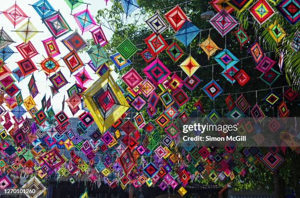 god's eyes (in spanish, ojos de dios) and ribbons hanging over a street in sayulita, nayarit, mexico - knit bombing stock pictures, royalty-free photos & images