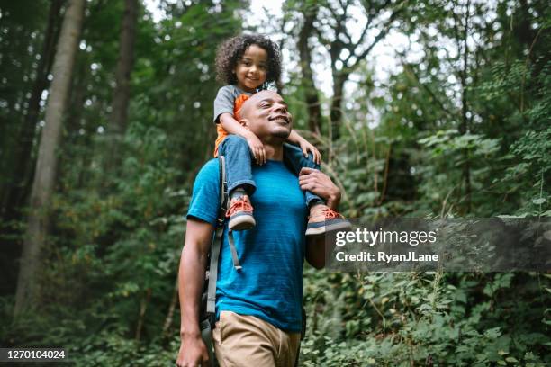 padre lleva a su hijo en caminata a través de sendero forestal en el noroeste del pacífico - padre e hijas fotografías e imágenes de stock