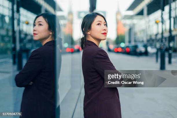 portrait of young professional woman - japanese bussiness woman looking up stock-fotos und bilder
