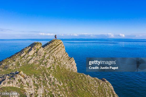 senior man standing on the edge of cliff - gower peninsula stock-fotos und bilder