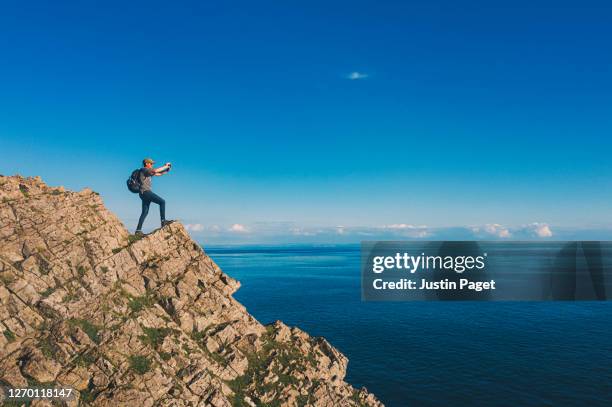 man taking photo of view with smartphone - rhossili stock pictures, royalty-free photos & images