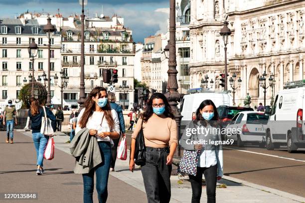 women in the street, wearing face protective mask to prevent coronavirus. - france coronavirus stock pictures, royalty-free photos & images