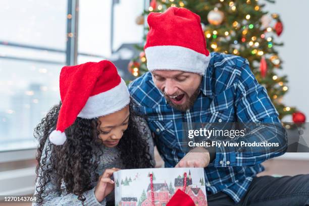 クリスマスの日にプレゼントを開くことに興奮 - adopted chinese daughter ストックフォトと画像