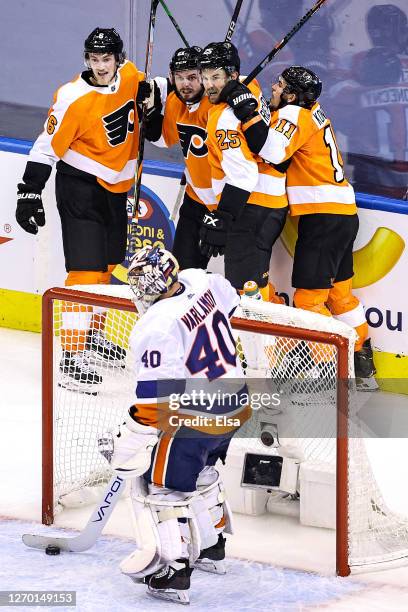 Semyon Varlamov of the New York Islanders is congratulated by his teammates after scoring a goal past Semyon Varlamov of the New York Islanders...