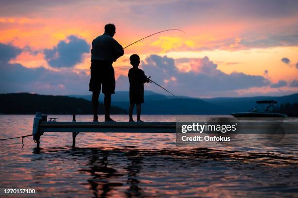 grandfather and grandson fishing in summer - fishing silhouette stock pictures, royalty-free photos & images