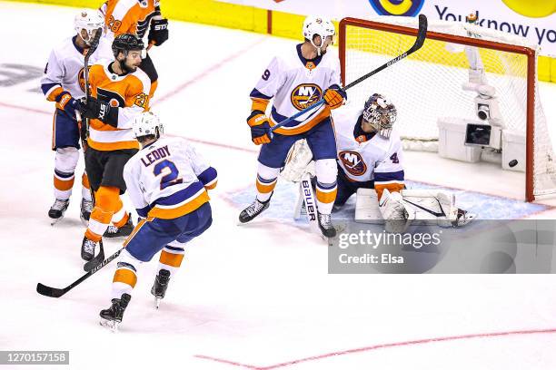 Scott Laughton of the Philadelphia Flyers deflects the shot and scores the game-winning goal past Semyon Varlamov of the New York Islanders during...