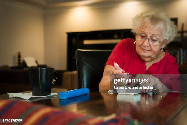 woman organizing medication into pill organizers - indiana home stock pictures, royalty-free photos & images