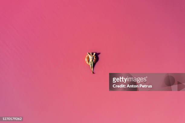 man swims in the pink water of a salt lake - aerial beach view sunbathers stock pictures, royalty-free photos & images