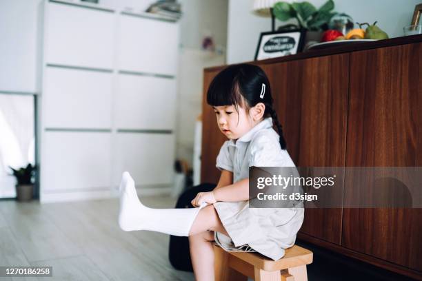 smart little asian school girl getting dressed in the living room and preparing for her first day at school - get dressed male stock-fotos und bilder