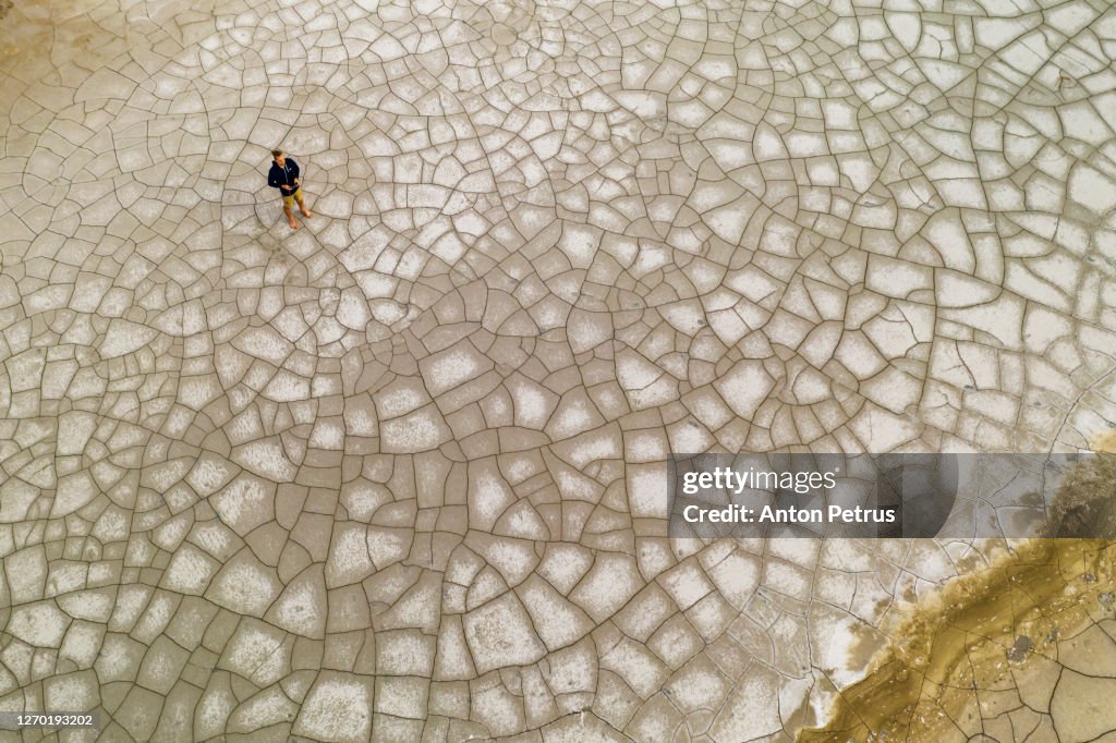Aerial view of a man on the cracked ground. Global warming concept