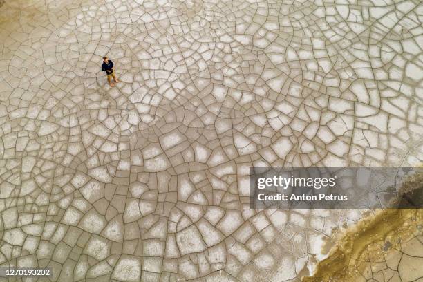 aerial view of a man on the cracked ground. global warming concept - ukraine landscape stock-fotos und bilder