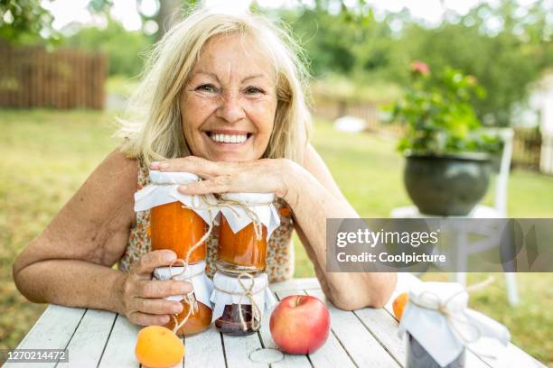 senior woman with home-mede marmalade - marmalade foto e immagini stock