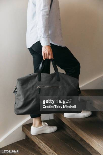 man with duffel bag climbing wood stairs - mochila con cuerdas fotografías e imágenes de stock