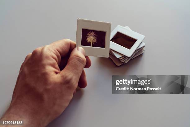hand holding photographic slides - dia stockfoto's en -beelden