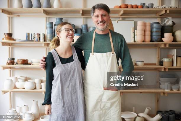 smiling male and female coworkers in art studio - ceramic imagens e fotografias de stock