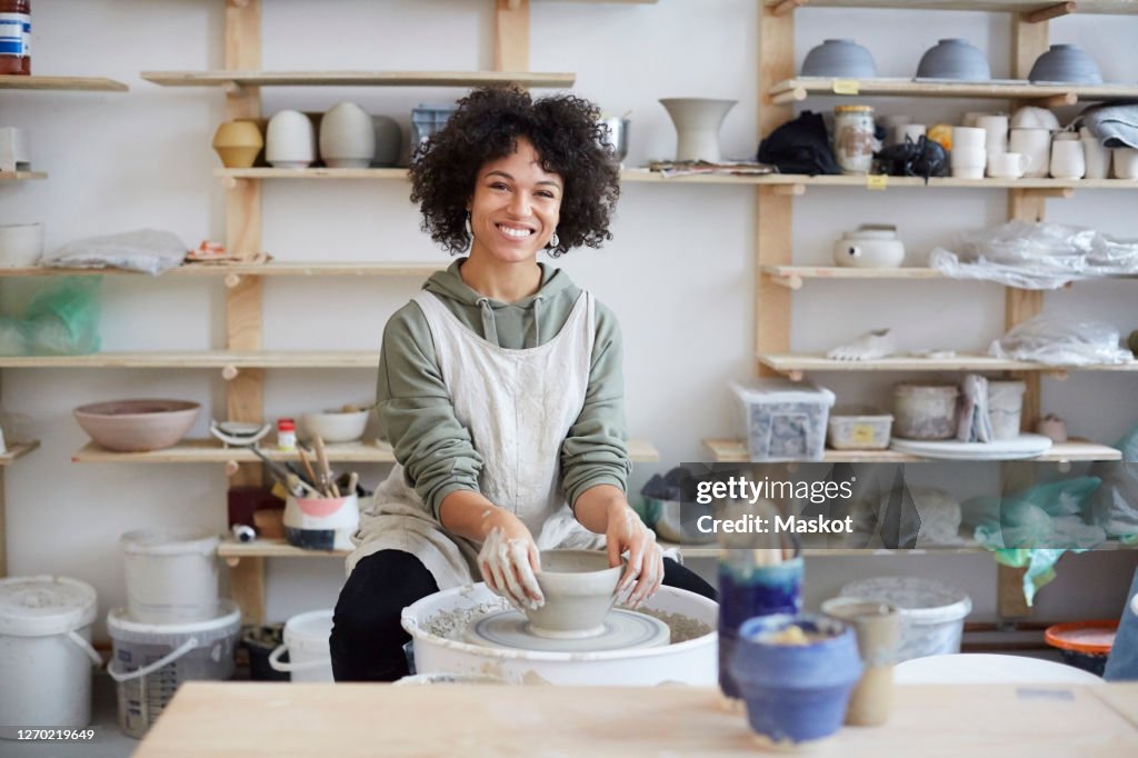 Portrait of smiling woman learning pottery in art studio