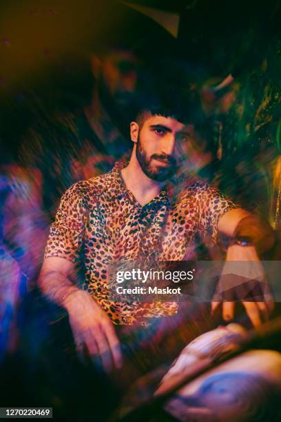 multiple exposure of young man in leopard print casual sitting at restaurant - leopard print stock pictures, royalty-free photos & images