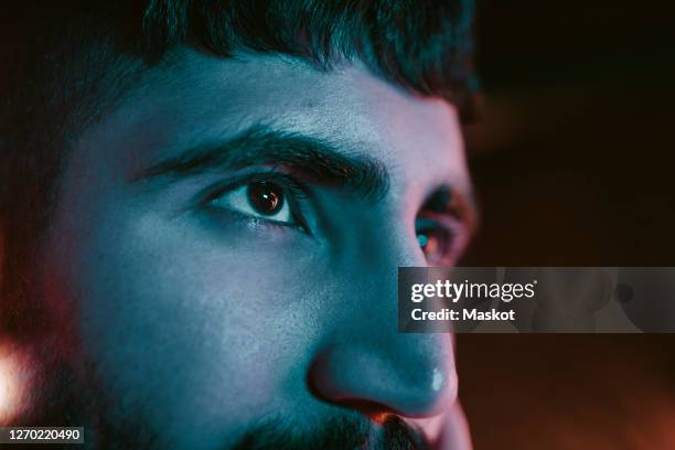 cropped image of young man looking away at bar - augen mann stock-fotos und bilder