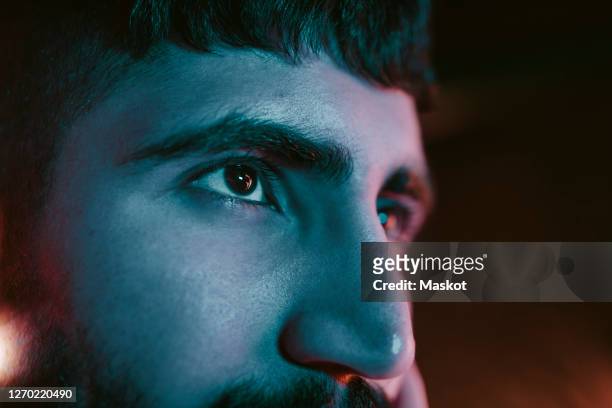 cropped image of young man looking away at bar - effet miroir homme photos et images de collection