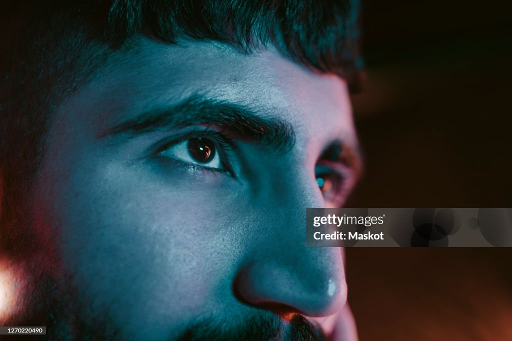 Cropped image of young man looking away at bar