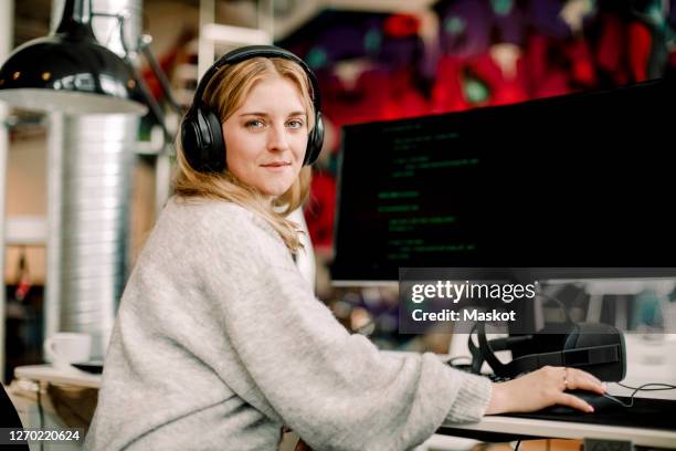 portrait of female computer programmer sitting in office - woman coding stockfoto's en -beelden