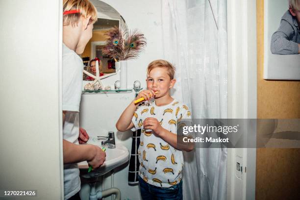portrait of boy brushing teeth in morning - flash stock pictures, royalty-free photos & images