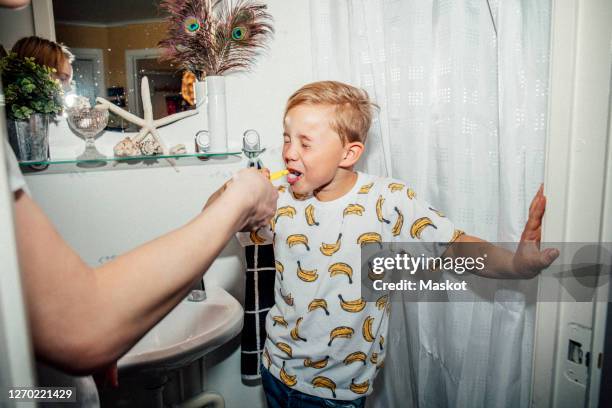 boy brushing teeth in bathroom - brothers bathroom stock-fotos und bilder