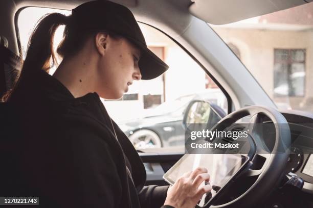 side view of driver using digital tablet in truck - truck side view stock pictures, royalty-free photos & images